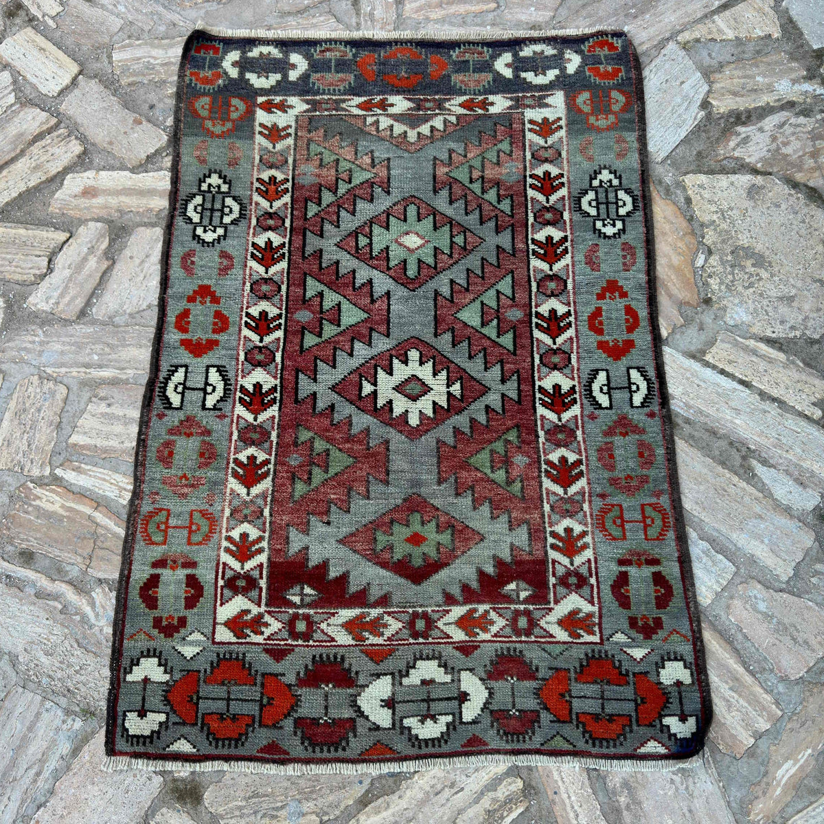 Blue 3' x 4' vintage turkish rug in wool and cotton, shown on the floor.