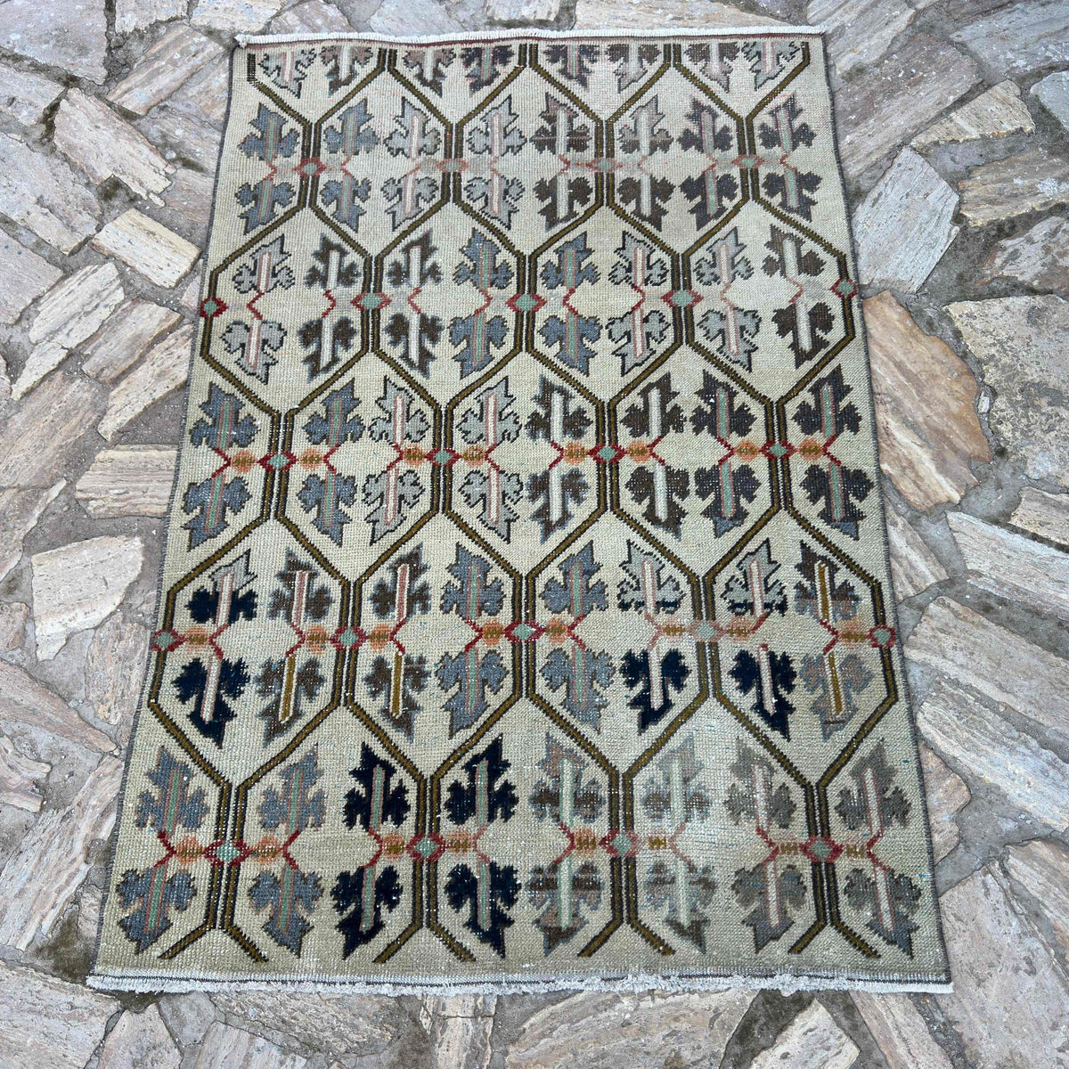 Beige 3' x 5' vintage turkish rug in wool and cotton, shown on the floor.