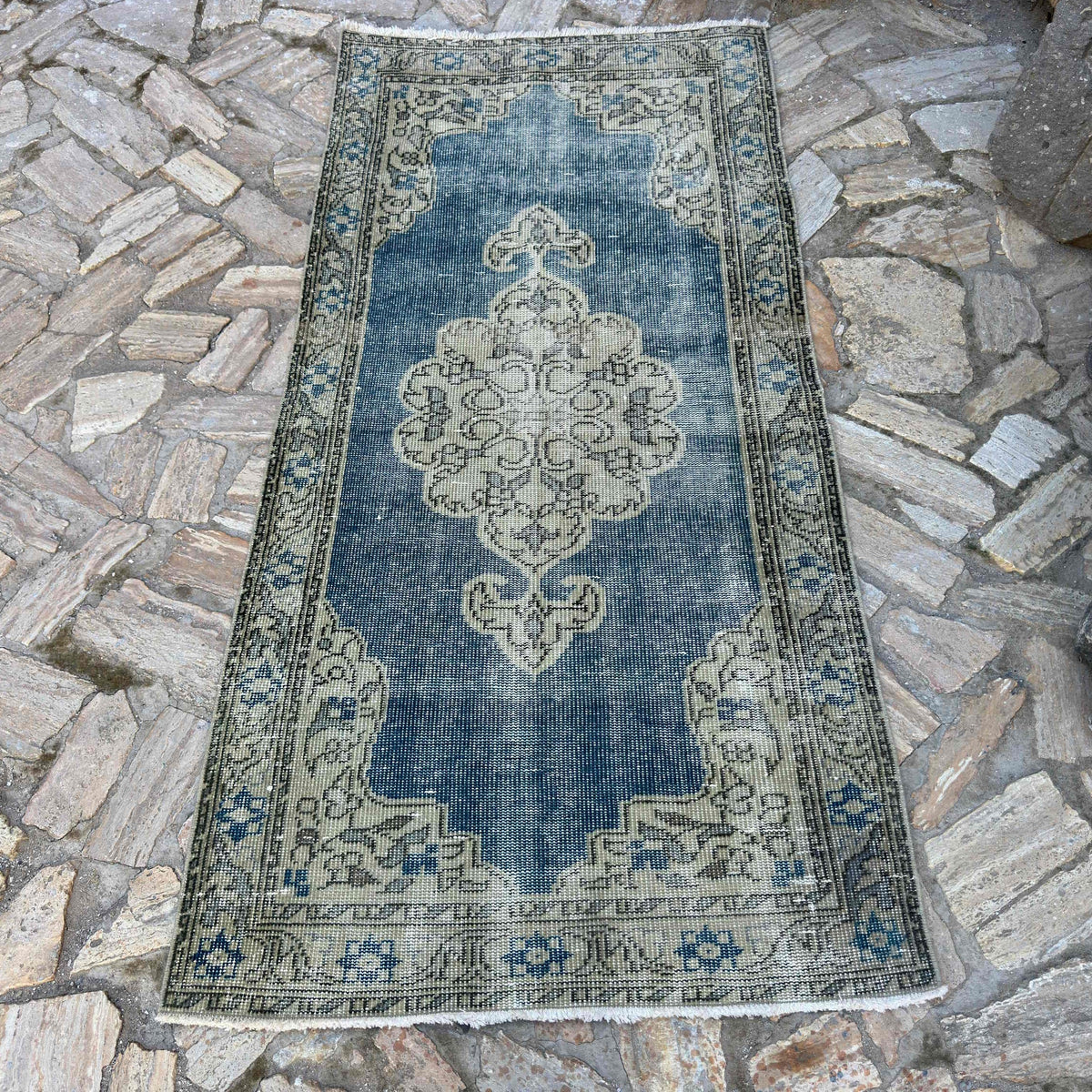Blue 3' x 6' vintage turkish rug in wool and cotton, shown on the floor.