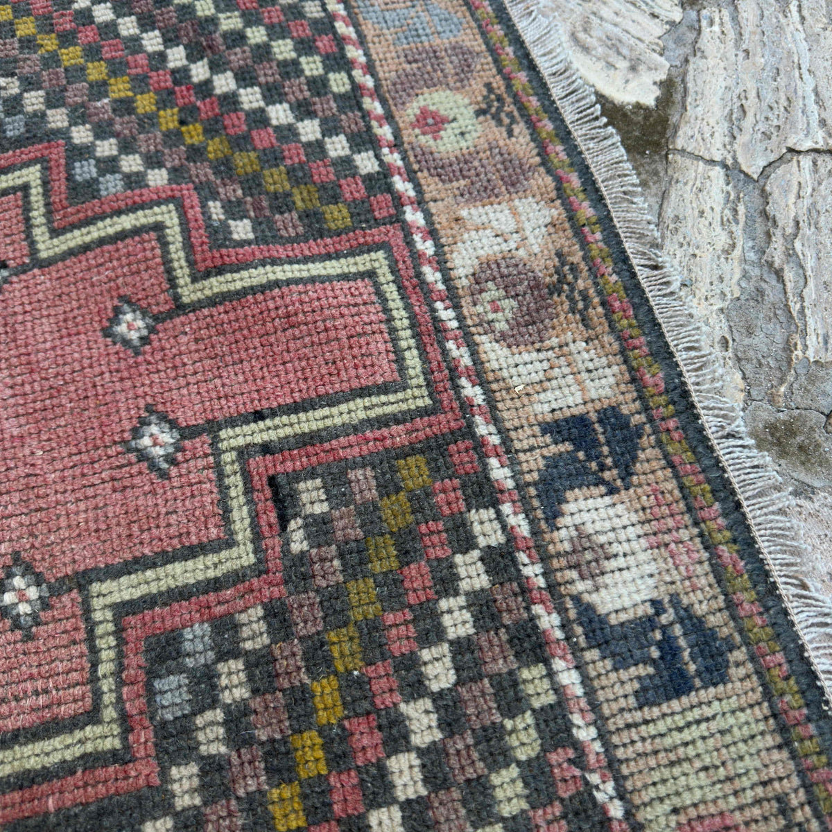 Close-up of the pink vintage turkish rug showing traditional details, hand-knotted weave, wool and cotton and low pile.