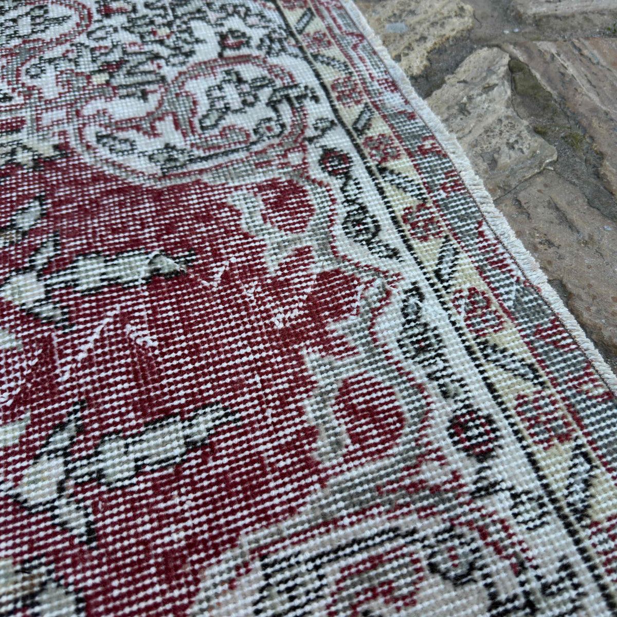 Close-up of the red vintage turkish rug showing traditional details, hand-knotted weave, wool and cotton and low pile.