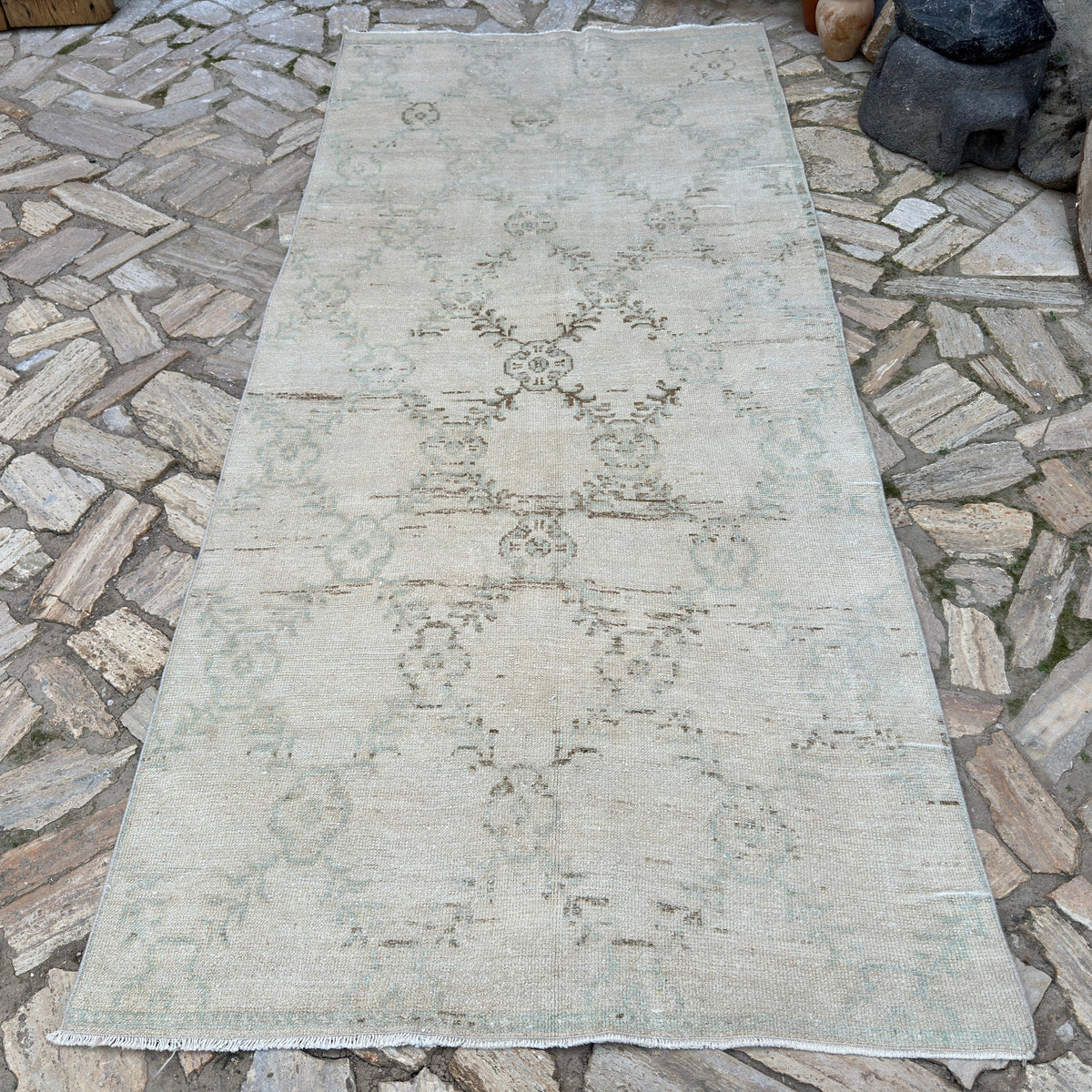 Beige 4' x 10' vintage turkish rug in wool and cotton, shown on the floor.