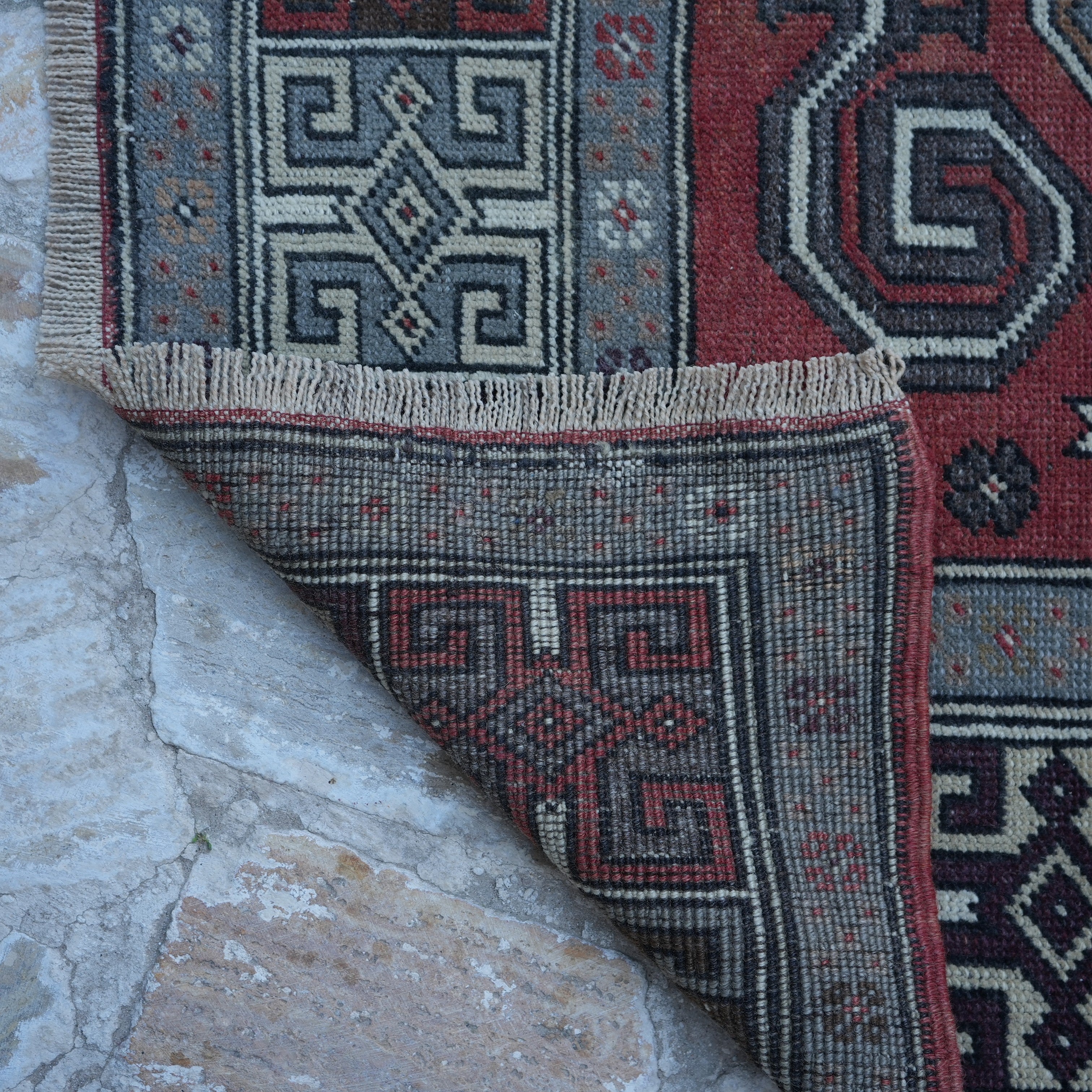 1970s red vintage turkish rug with geometric design, hand-knotted weave and low pile.