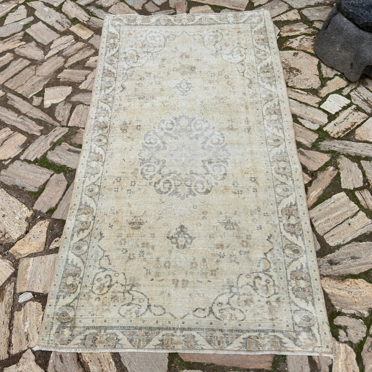 Beige 4' x 7' vintage turkish rug in wool and cotton, shown on the floor.