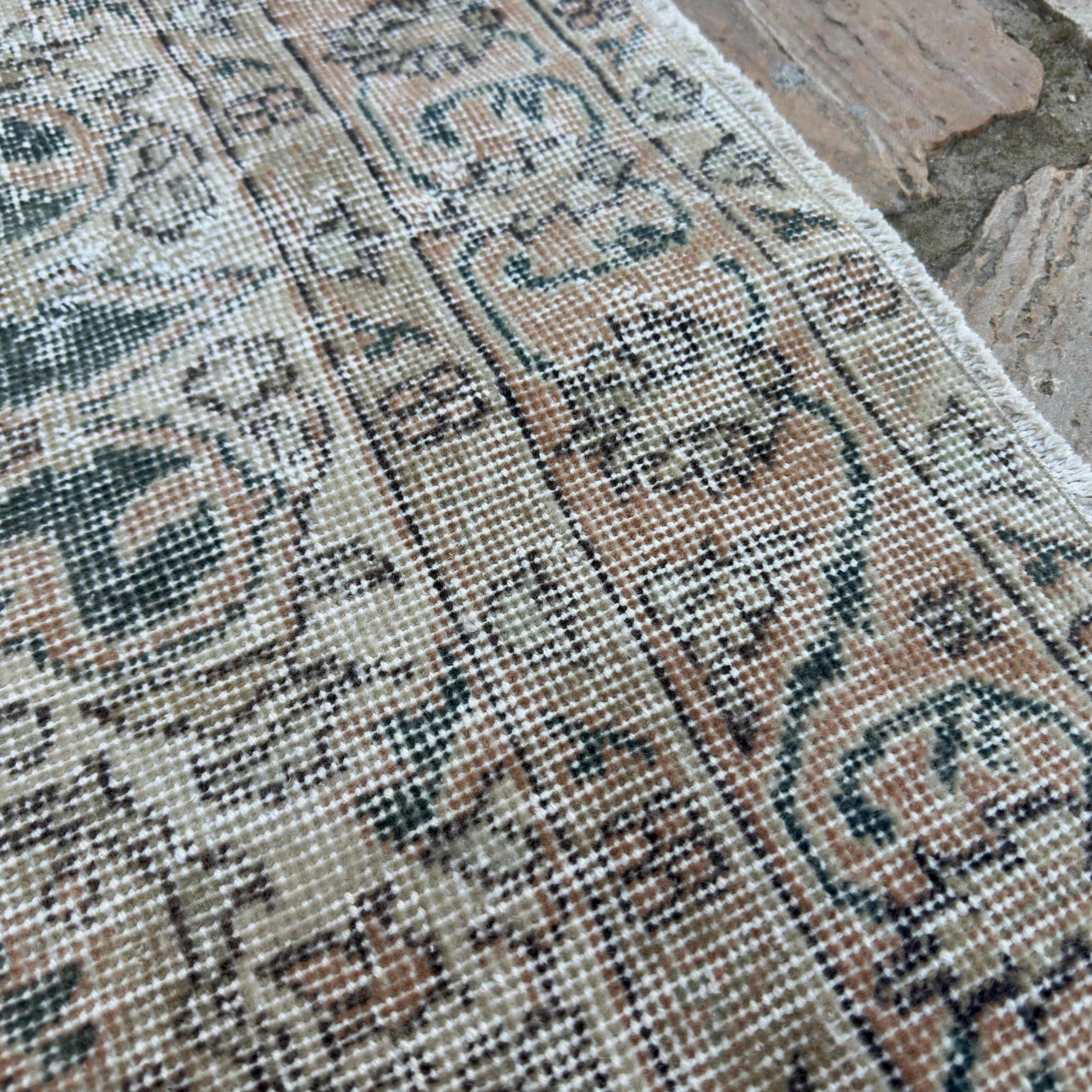 Close-up of the blue vintage turkish rug showing neutral details, hand-knotted weave, wool and cotton and low pile.