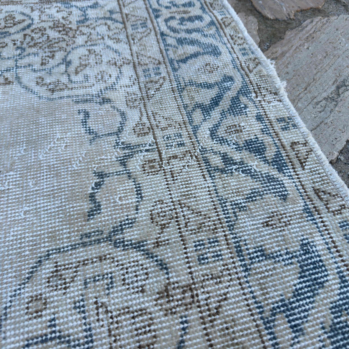 Close-up of the blue vintage turkish rug showing medallion details, hand-knotted weave, wool and cotton and low pile.