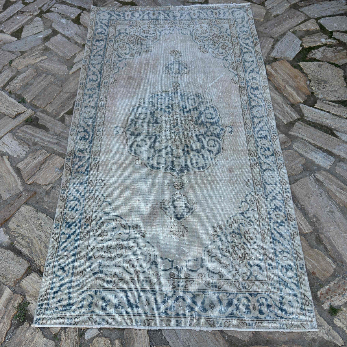Blue 4' x 7' vintage turkish rug in wool and cotton, shown on the floor.