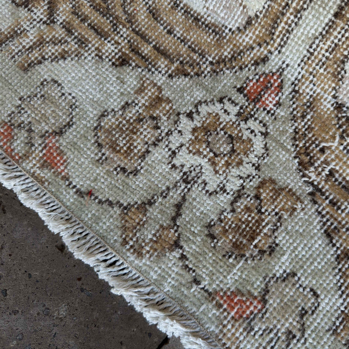 Close-up of the green vintage turkish rug showing traditional details, hand-knotted weave, wool and cotton and low pile.