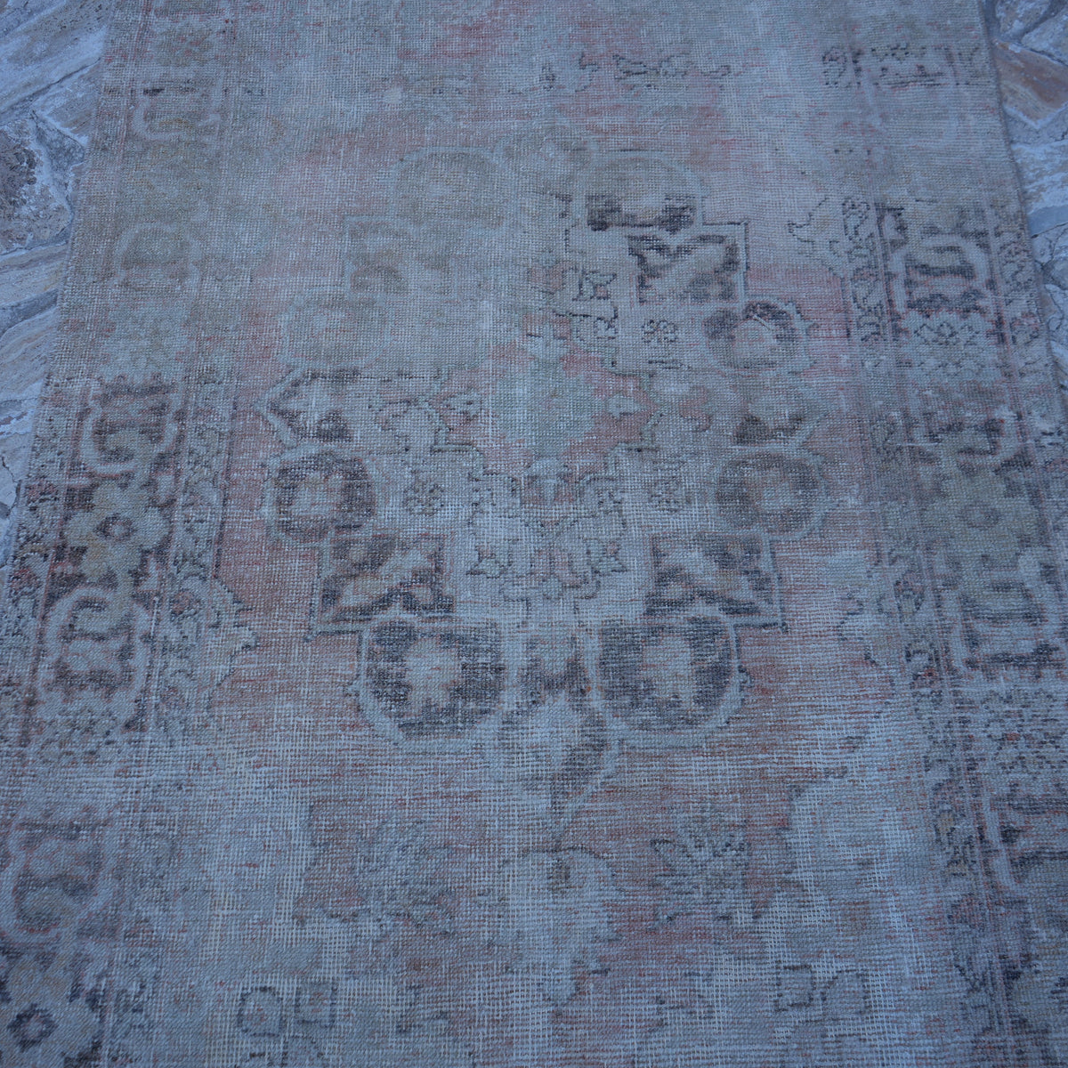 Close-up of the pale orange vintage turkish rug showing neutral details, hand-knotted weave, wool and cotton and low pile.