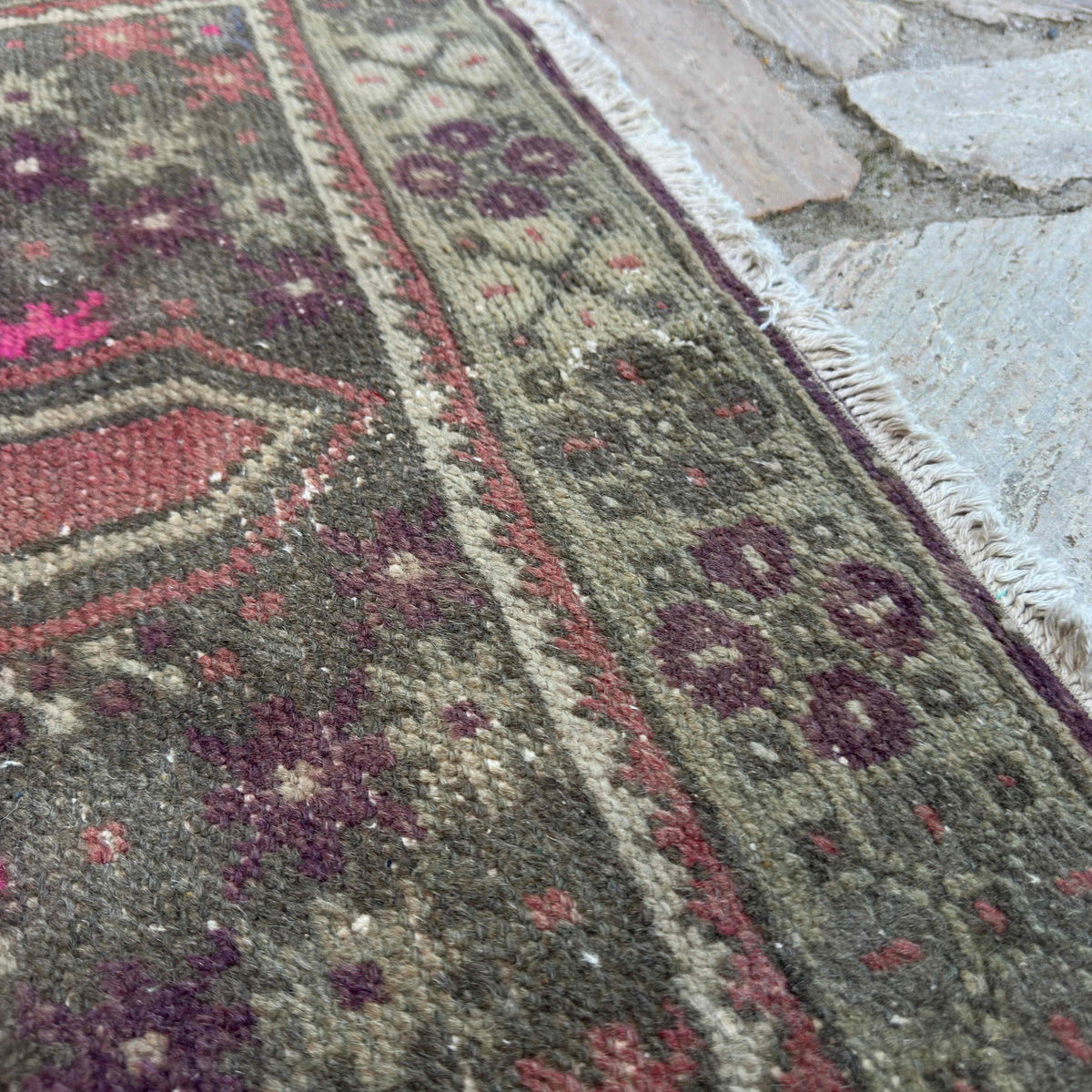 Close-up of the pink vintage turkish rug showing traditional details, hand-knotted weave, wool and cotton and low pile.