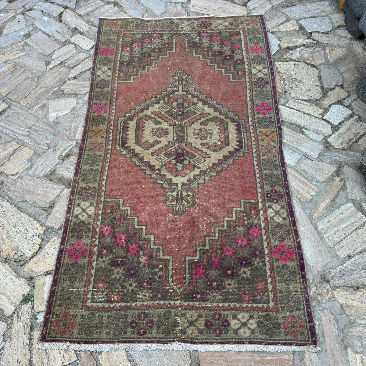 Pink 4' x 7' vintage turkish rug in wool and cotton, shown on the floor.