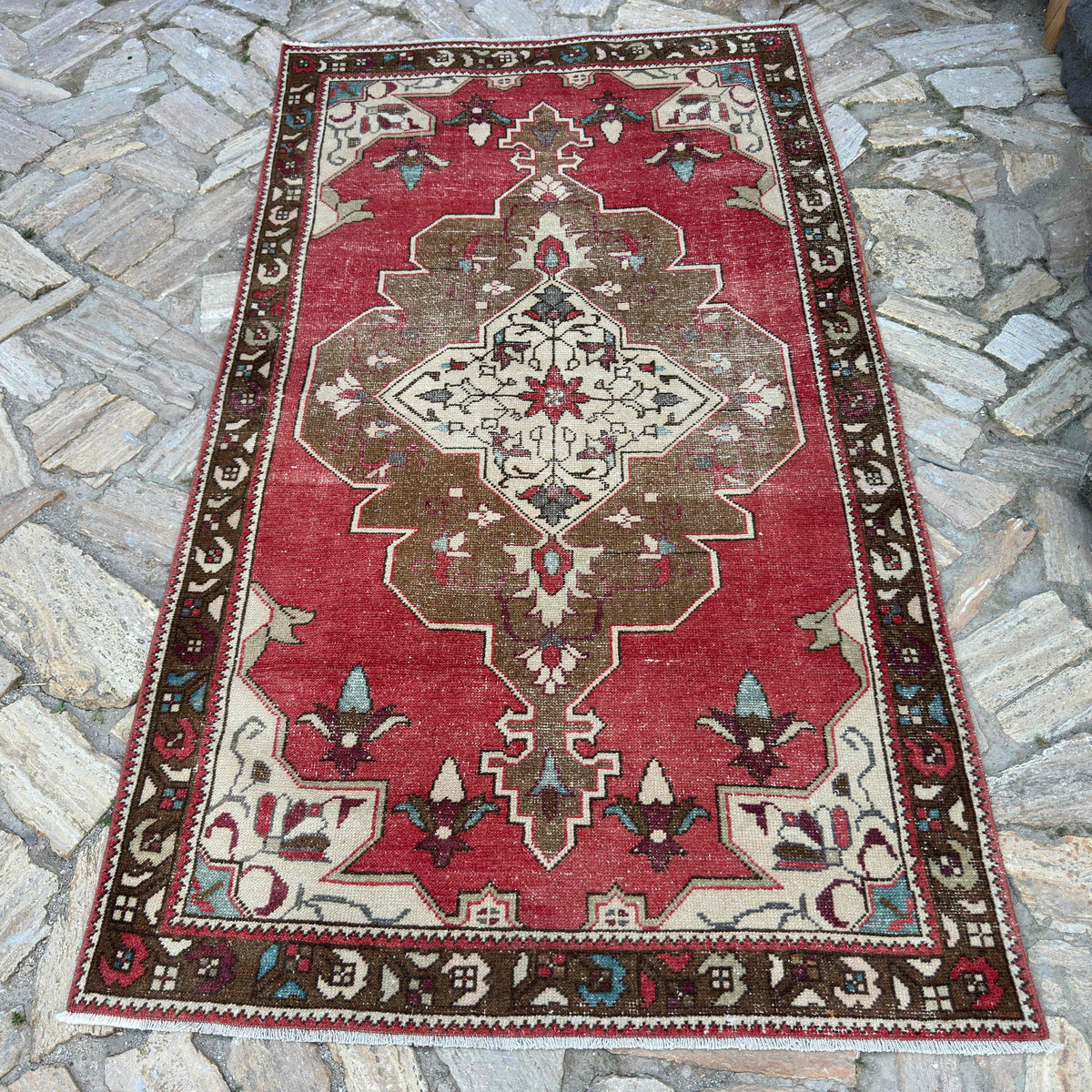 Red 4' x 7' vintage turkish rug in wool and cotton, shown on the floor.