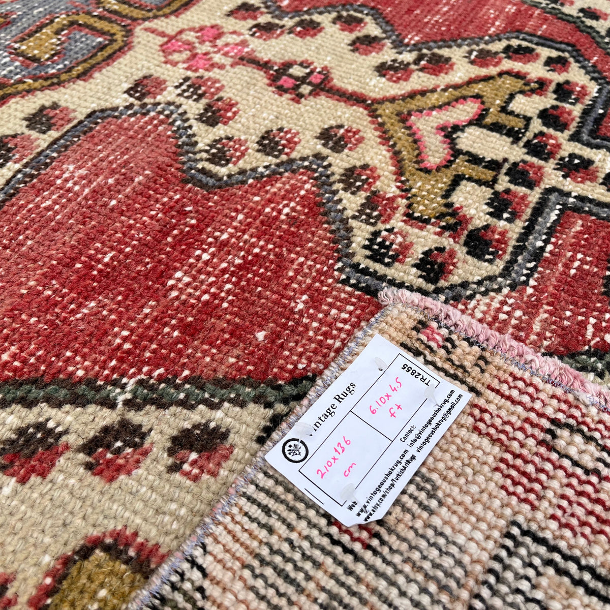 Close-up of the red vintage turkish rug showing traditional details, hand-knotted weave, wool and cotton and low pile.