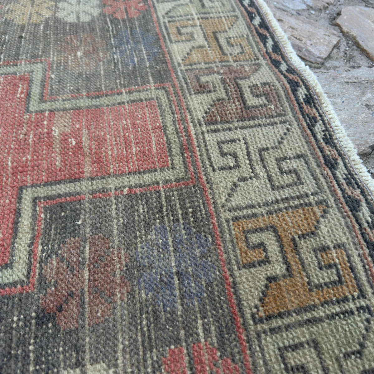 Close-up of the beige vintage turkish rug showing traditional details, hand-knotted weave, wool and cotton and low pile.