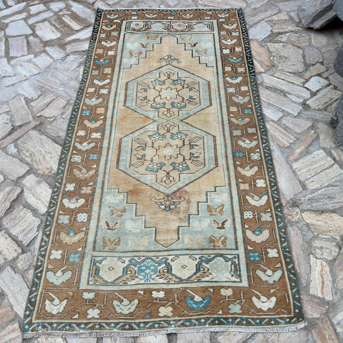Brown 4' x 8' vintage turkish rug in wool and cotton, shown on the floor.