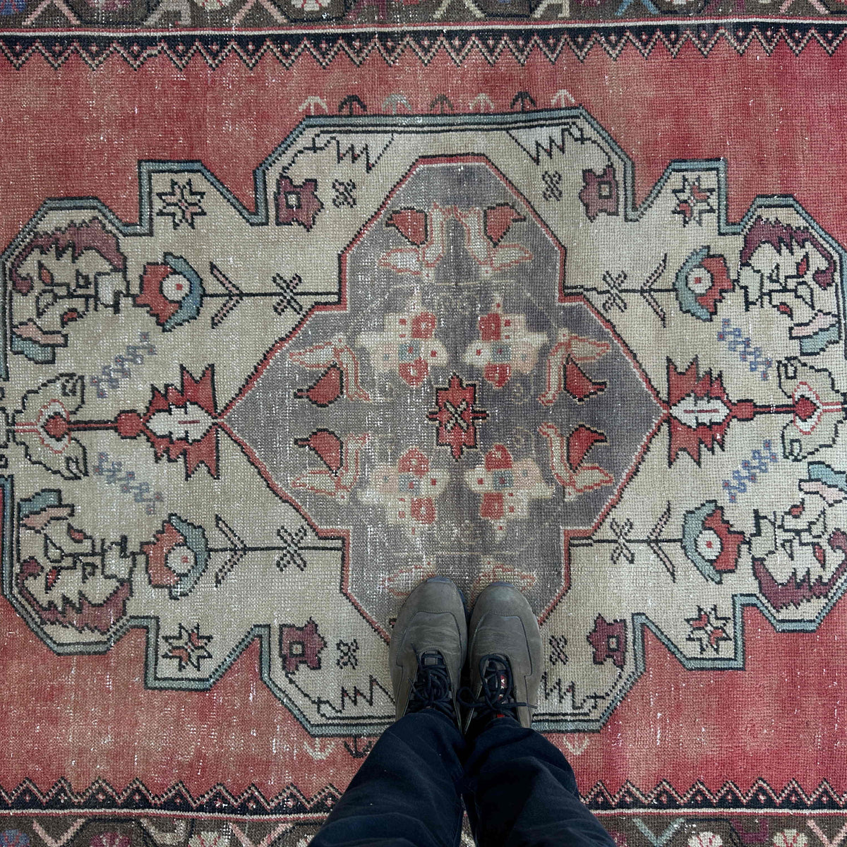 1970s pale red vintage turkish rug with medallion design, hand-knotted weave and low pile.