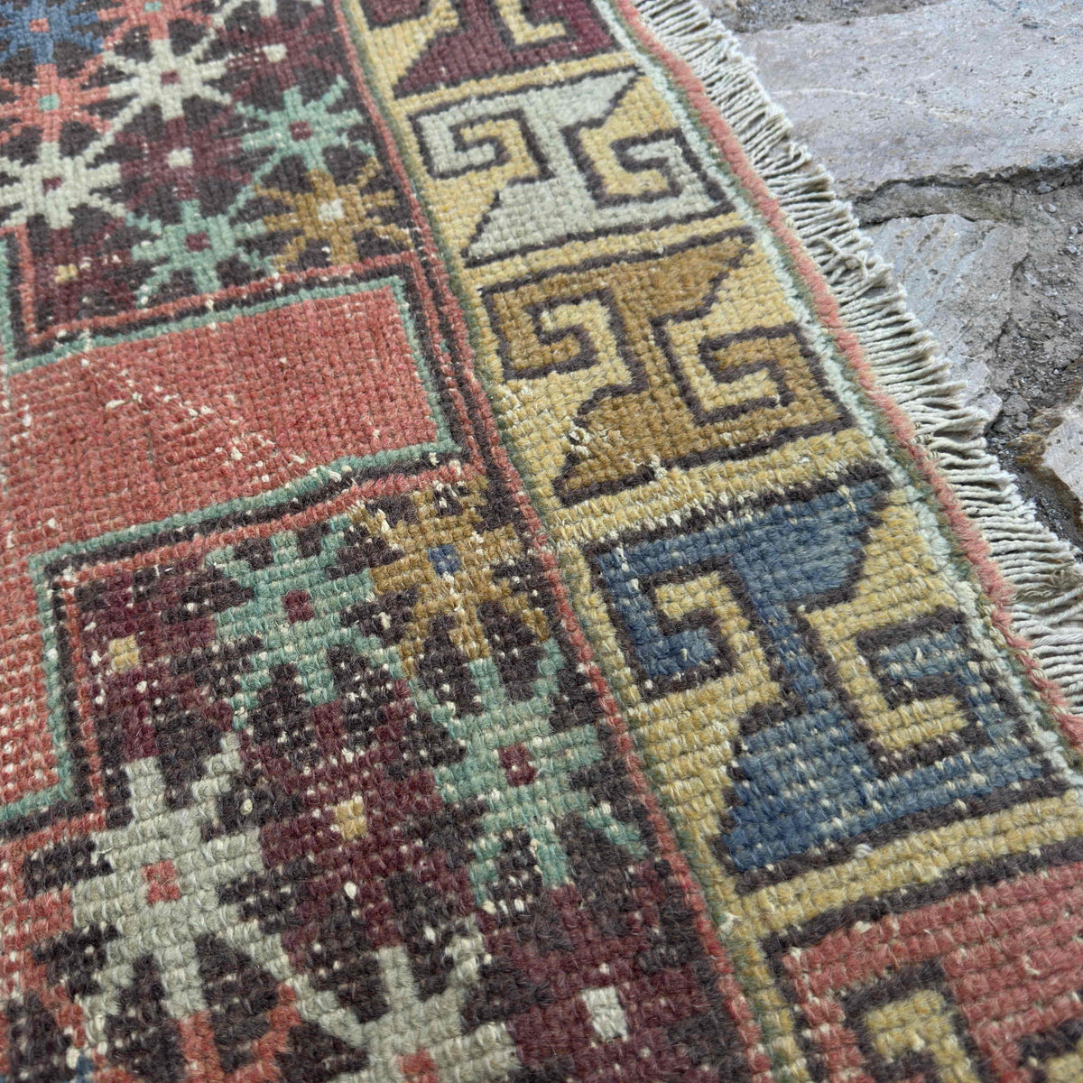 Close-up of the pink vintage turkish rug showing traditional details, hand-knotted weave, wool and cotton and low pile.