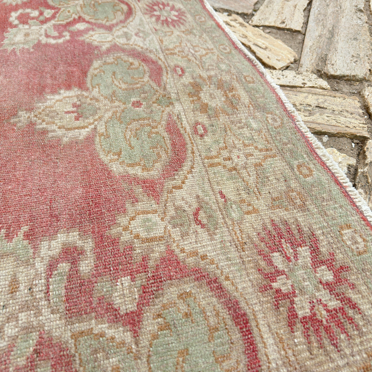Close-up of the red vintage turkish rug showing traditional details, hand-knotted weave, wool and cotton and low pile.
