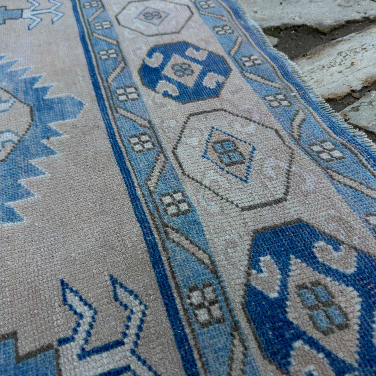 Close-up of the blue vintage turkish rug showing traditional details, hand-knotted weave, wool and cotton and low pile.