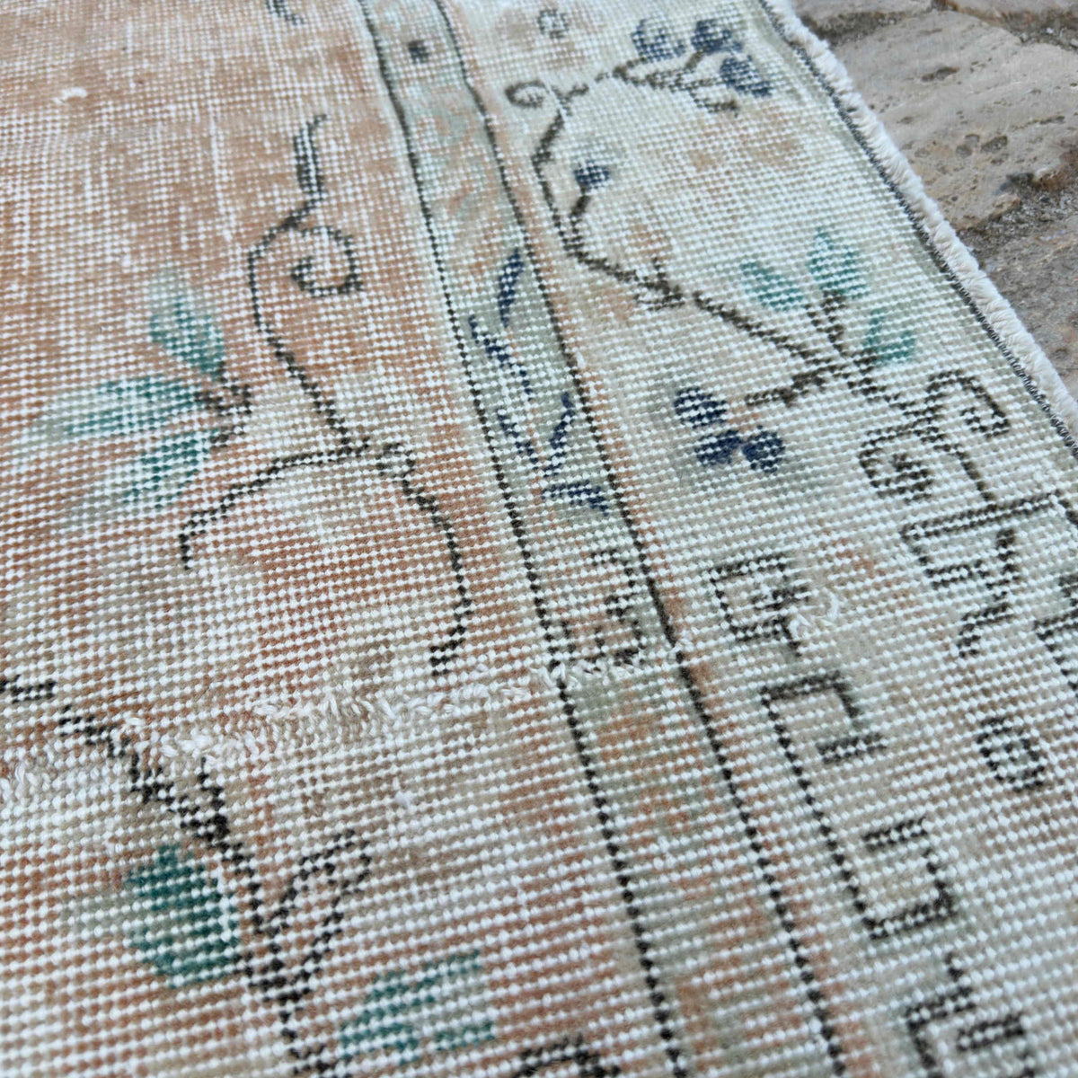 Close-up of the orange vintage turkish rug showing medallion details, hand-knotted weave, wool and cotton and low pile.
