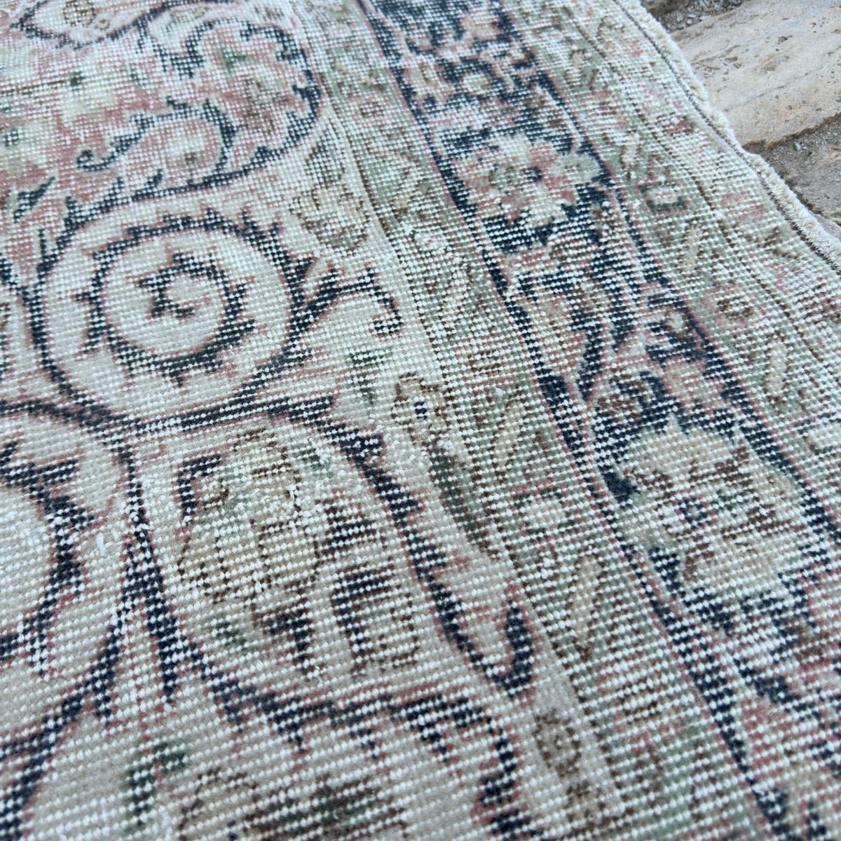 Close-up of the pink vintage turkish rug showing medallion details, hand-knotted weave, wool and cotton and low pile.