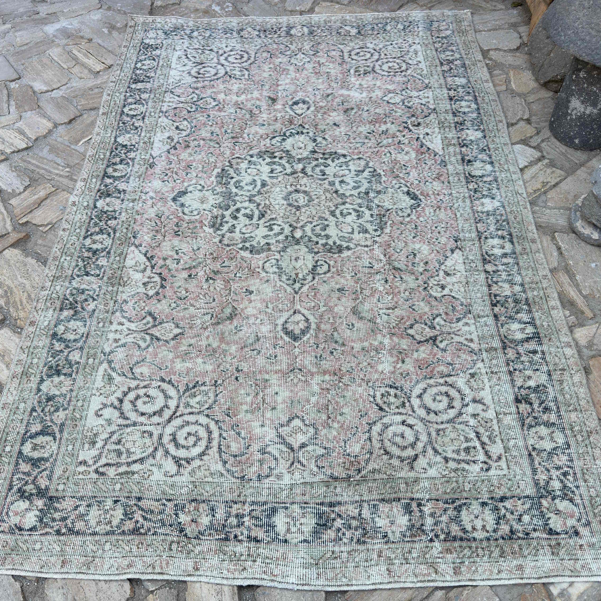 Pink 5' x 8' vintage turkish rug in wool and cotton, shown on the floor.