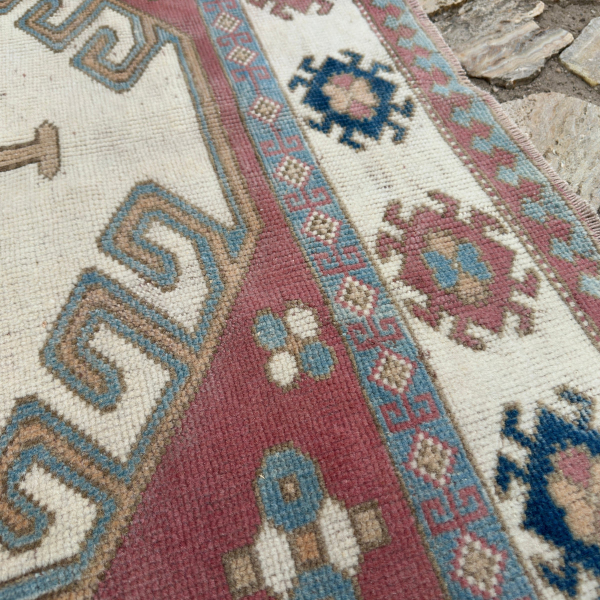 Close-up of the pink vintage turkish rug showing traditional details, hand-knotted weave, wool and cotton and low pile.