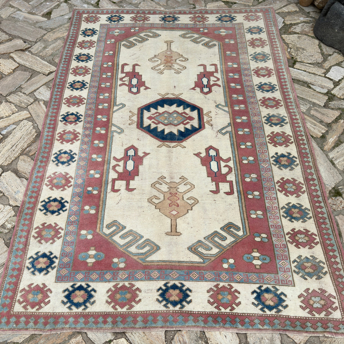Pink 5' x 8' vintage turkish rug in wool and cotton, shown on the floor.