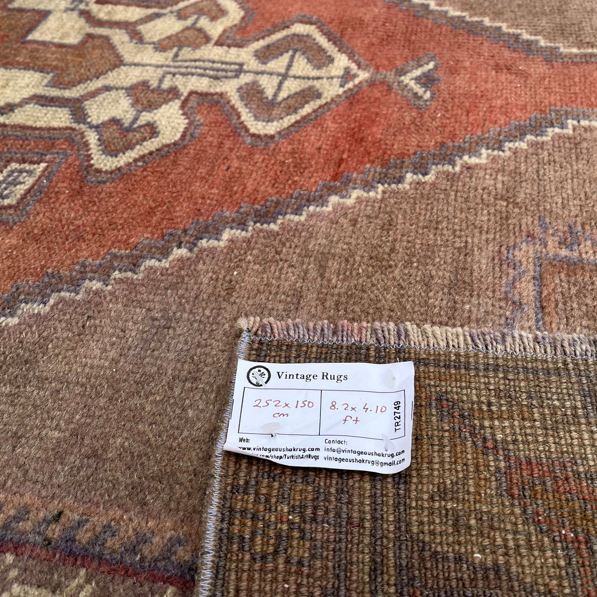 Close-up of the red vintage turkish rug showing traditional details, hand-knotted weave, wool and cotton and low pile.