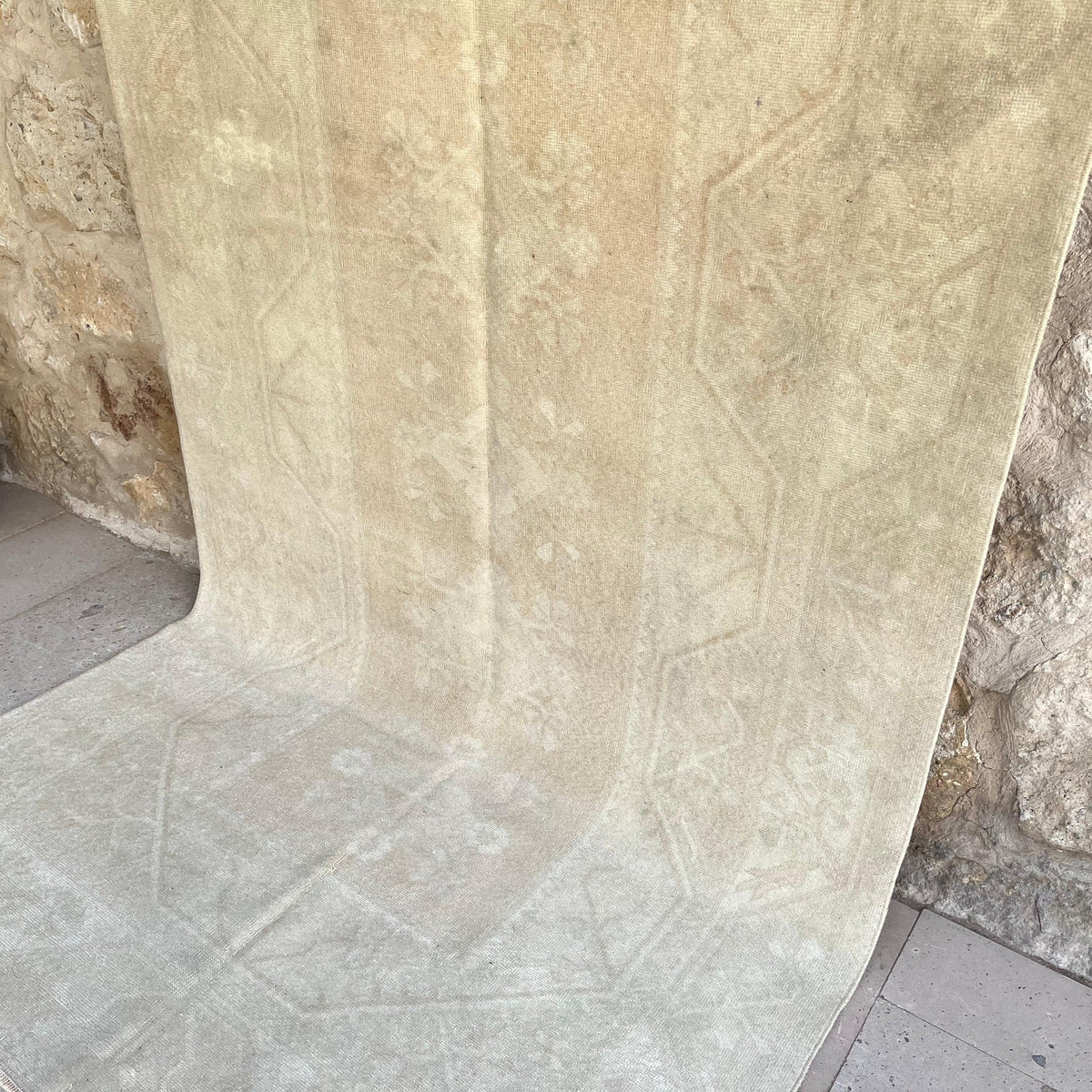 Beige 5' x 9' vintage turkish rug in wool and cotton, shown on the floor.