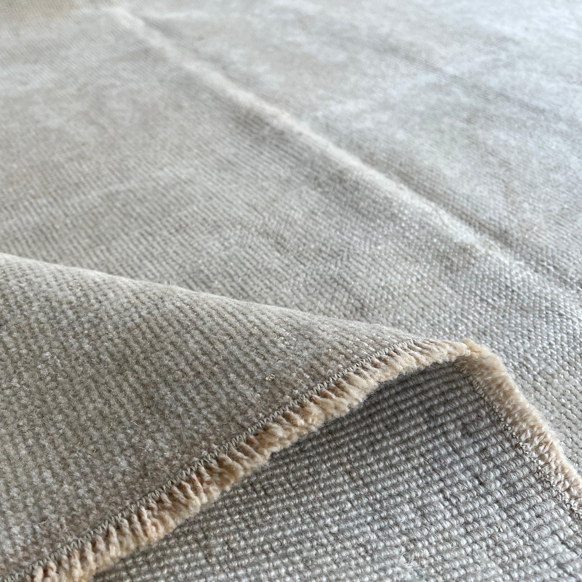 1970s beige vintage turkish rug with neutral design, hand-knotted weave and low pile.