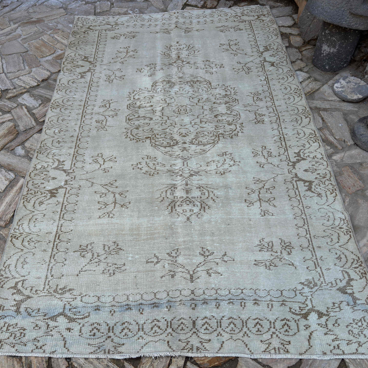 Beige 6' x 10' vintage turkish rug in wool and cotton, shown on the floor.