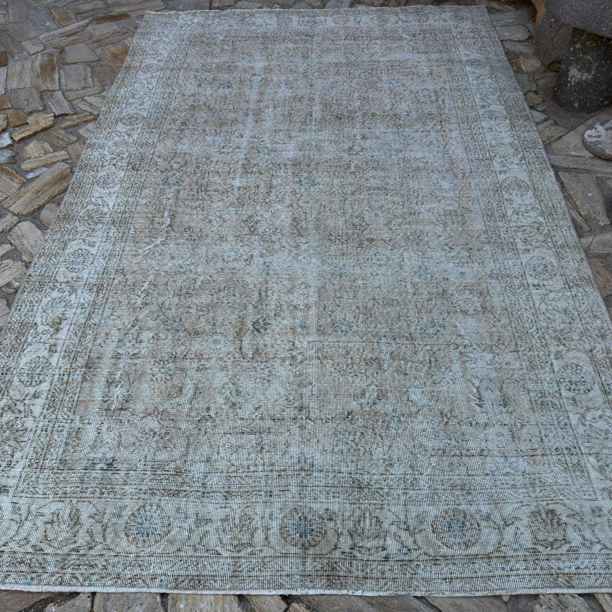 Beige 6' x 10' vintage turkish rug in wool and cotton, shown on the floor.