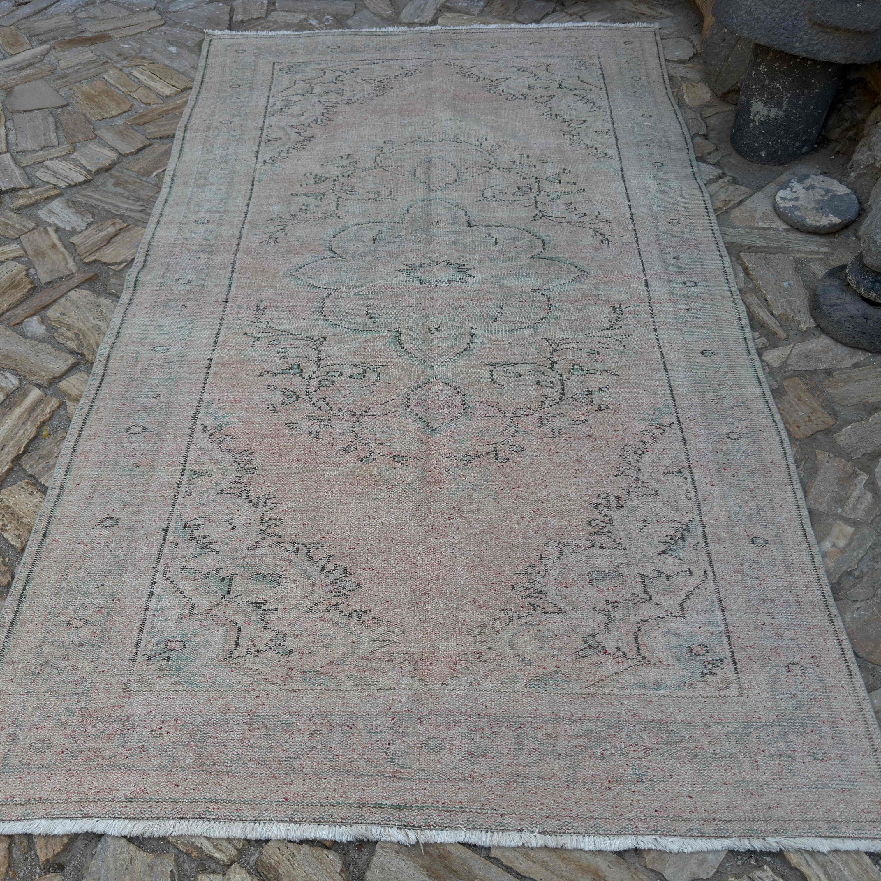 Beige 6' x 10' vintage turkish rug in wool and cotton, shown on the floor.