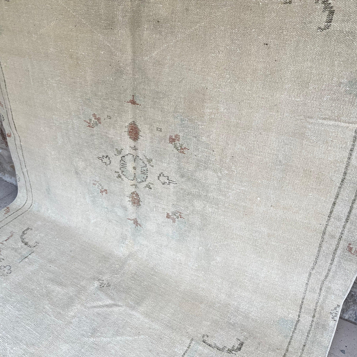 Beige 6' x 10' vintage turkish rug in wool and cotton, shown on the floor.