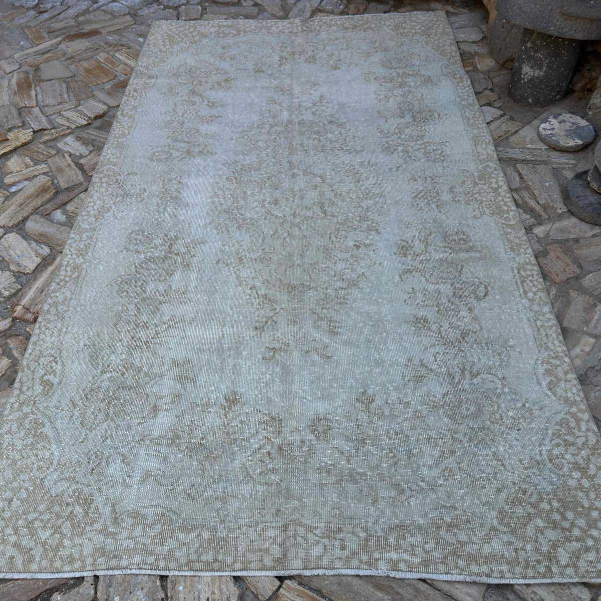 Beige 6' x 10' vintage turkish rug in wool and cotton, shown on the floor.