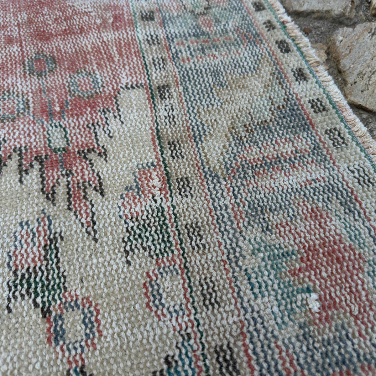 Close-up of the pink vintage turkish rug showing medallion details, hand-knotted weave, wool and cotton and low pile.