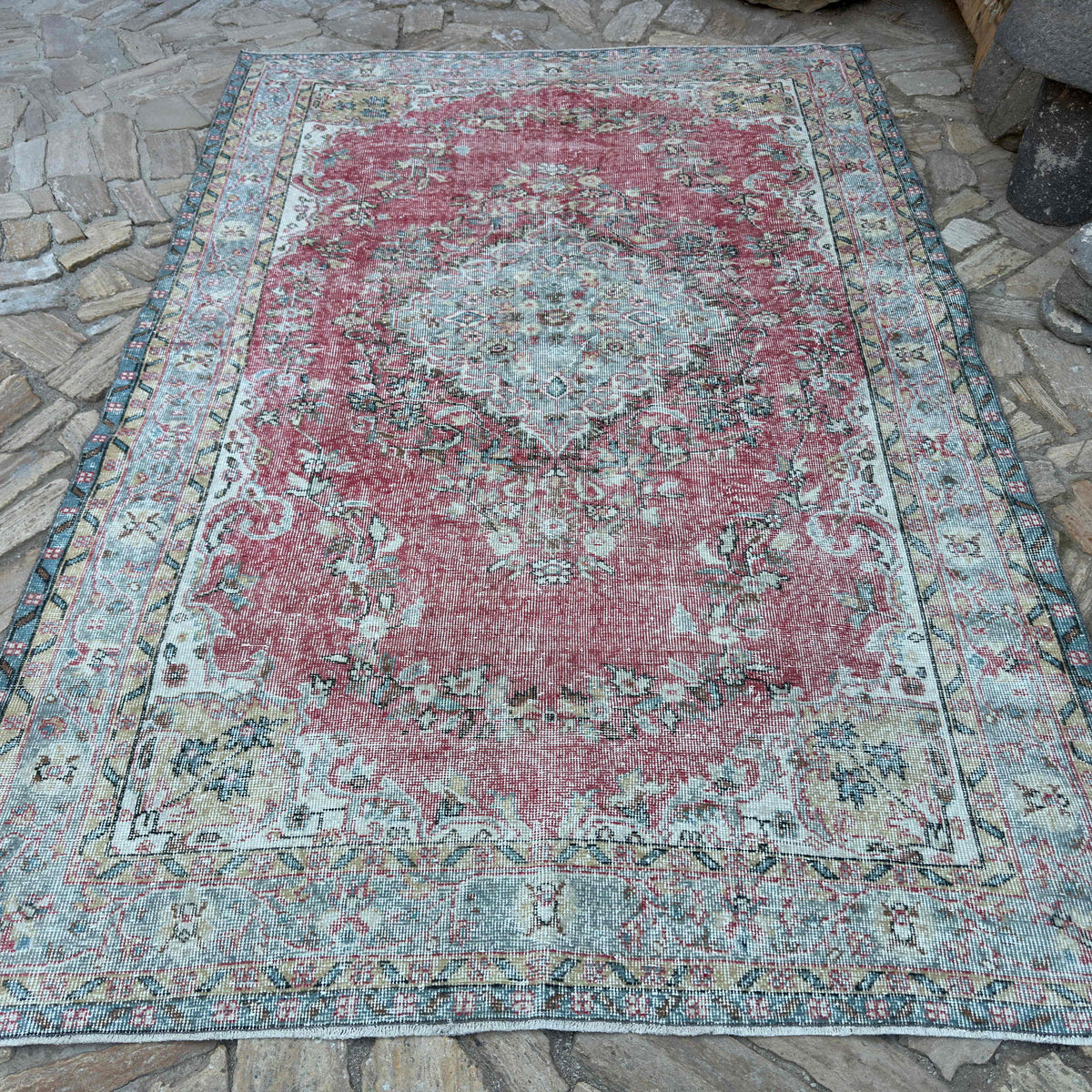 Red 6' x 10' vintage turkish rug in wool and cotton, shown on the floor.
