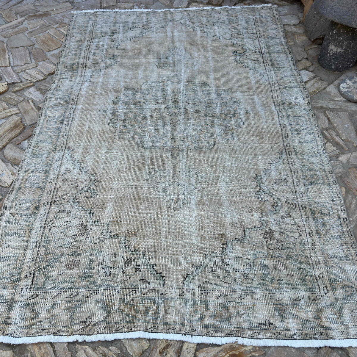Beige 6' x 9' vintage turkish rug in wool and cotton, shown on the floor.