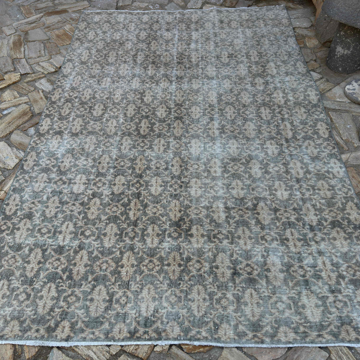 Gray 7' x 10' vintage turkish rug in wool and cotton, shown on the floor.