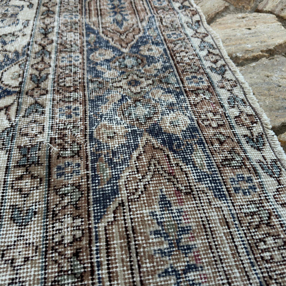 Close-up of the orange vintage turkish rug showing medallion details, hand-knotted weave, wool and cotton and low pile.
