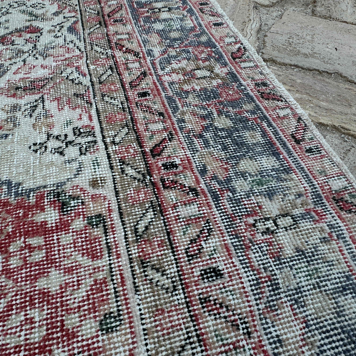 Close-up of the beige vintage turkish rug showing medallion details, hand-knotted weave, wool and cotton and low pile.