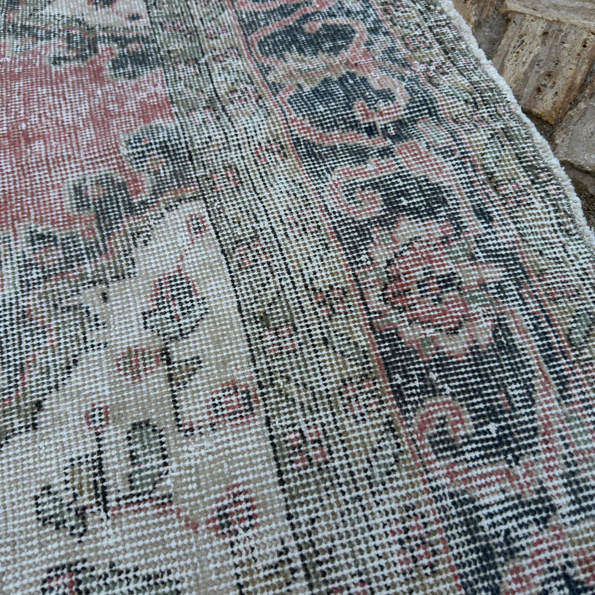 Close-up of the pink vintage turkish rug showing medallion details, hand-knotted weave, wool and cotton and low pile.