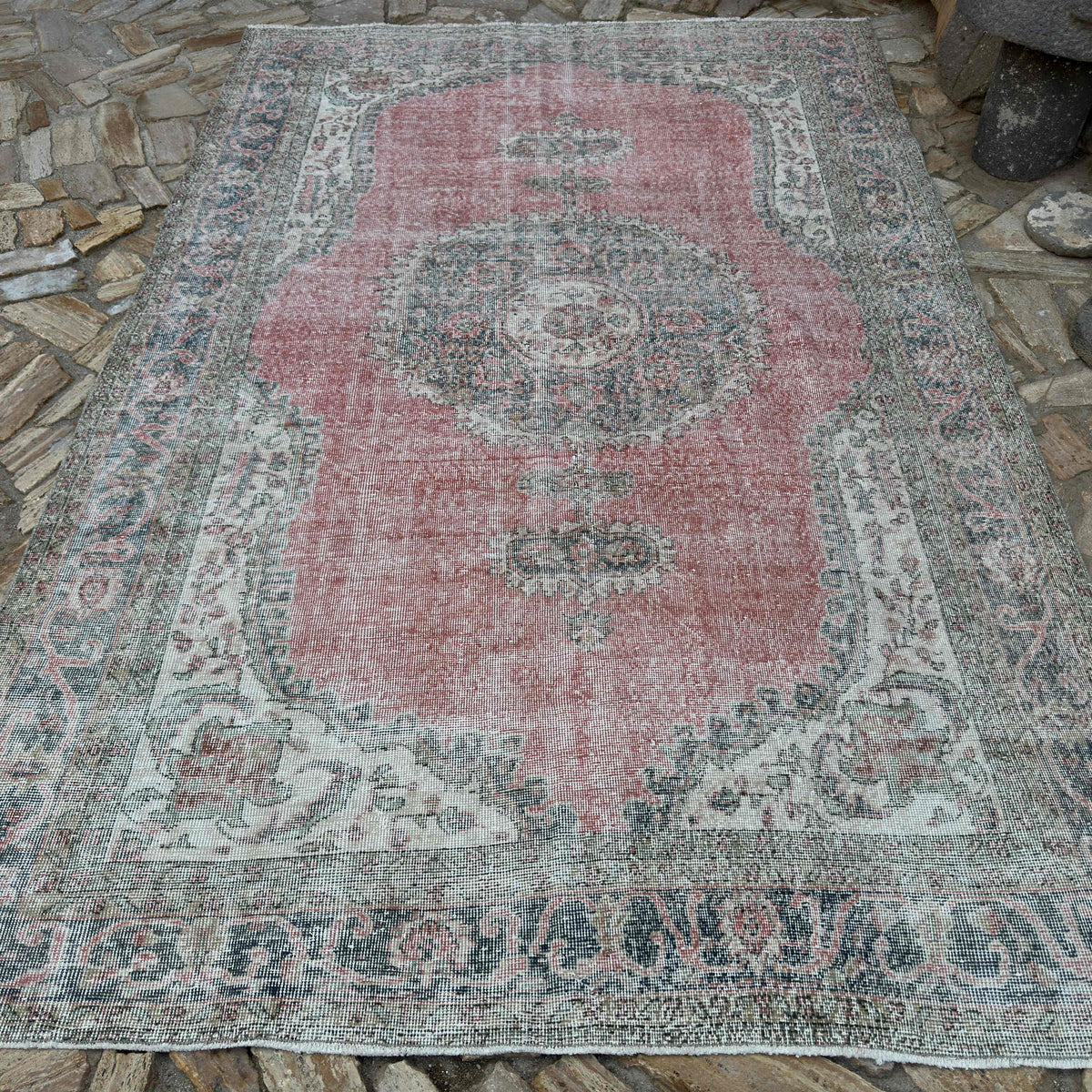 Pink 7' x 11' vintage turkish rug in wool and cotton, shown on the floor.