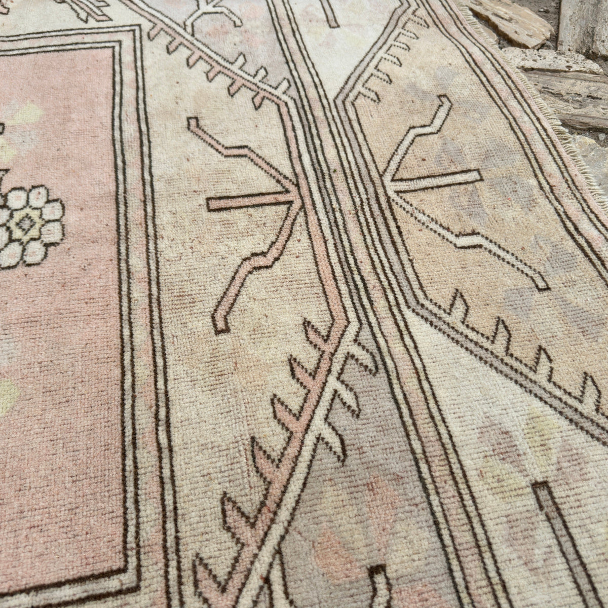 Close-up of the beige vintage turkish rug showing neutral details, hand-knotted weave, wool and cotton and low pile.