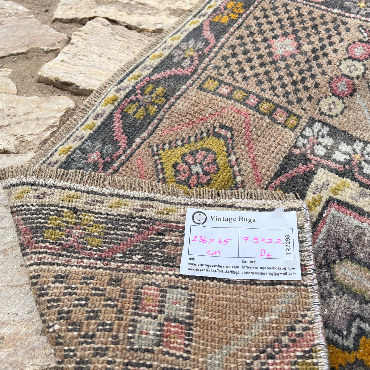 Close-up of the pink vintage turkish runner rug showing traditional details, hand-knotted weave, wool and cotton and low pile.