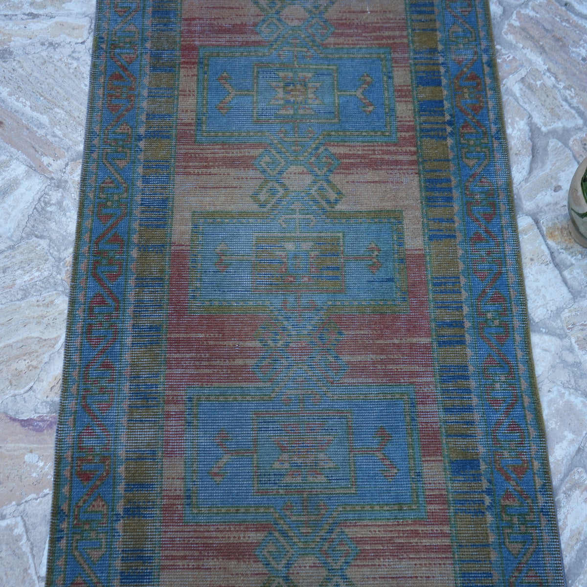 Close-up of the blue vintage turkish runner rug showing traditional details, hand-knotted weave, wool and cotton and low pile.