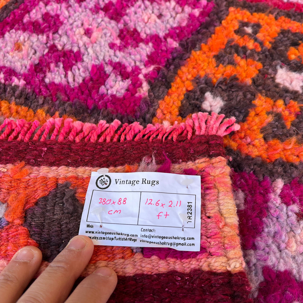 Close-up of the pink vintage turkish runner rug showing traditional details, hand-knotted weave, wool and cotton and medium pile.