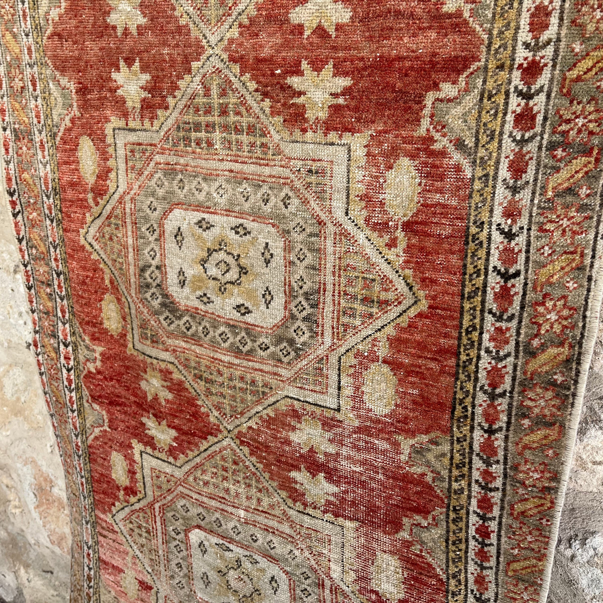 Close-up of the red vintage turkish runner rug showing traditional details, hand-knotted weave, wool and cotton and low pile.