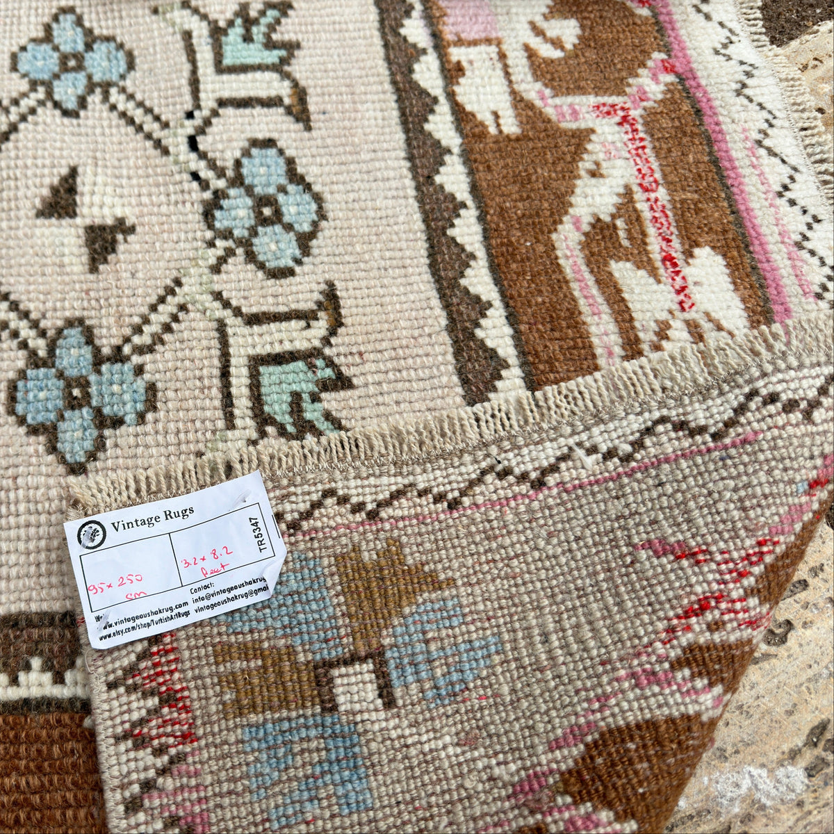 Close-up of the pale pink vintage turkish runner rug showing traditional details, hand-knotted weave, wool and cotton and low pile.